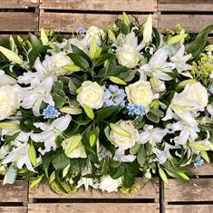 Cream with a sprinkle of blue casket spray