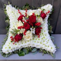 Cushion with a red and white corsage