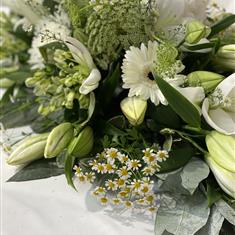 A florist choice Casket spray in white and cream