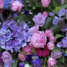 A florist choice Lilac, Pink and cerise casket spray 