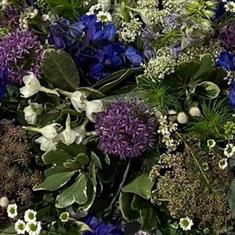 A Florist choice Purple, Blue, White and Lilac casket spray